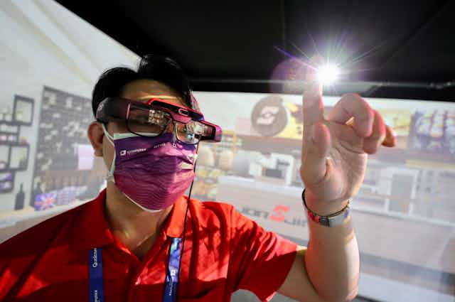 A staff member demonstrates a pair of Metaverse compatible glasses during the COMPUTEX 2022 exhibition in Taipei, Taiwan, 24 May 2022.