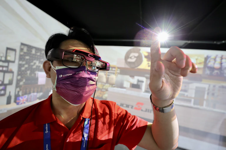 A staff member demonstrates a pair of Metaverse compatible glasses during the COMPUTEX 2022 exhibition in Taipei, Taiwan, 24 May 2022.