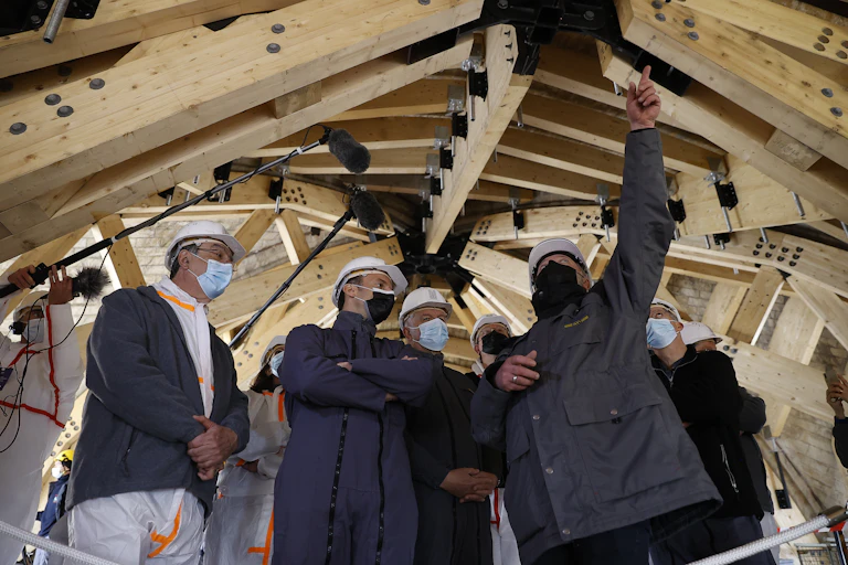 Emmanuel Macron et les responsables de la reconstruction de Notre-Dame dans les combles de la cathédrale