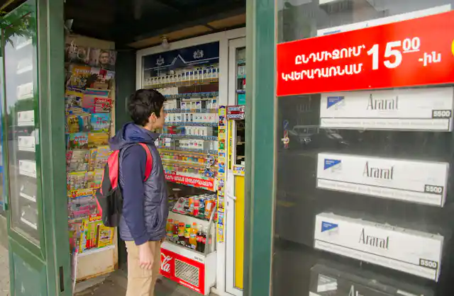 A young boy browses around an eye-level display of cigarettes.