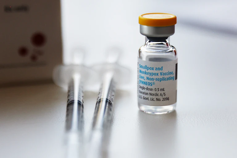 A bottle of vaccine next to two syringes.