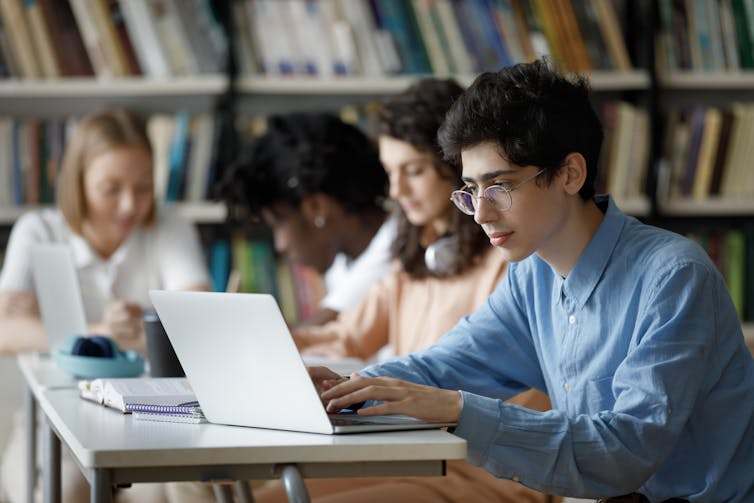 A person sitting at their computer looking pensive.