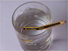 Un lápiz en un vaso de agua.