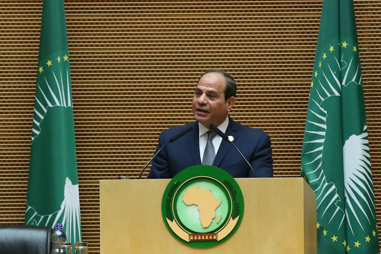 Man in suit, white shirt and tie, making a speech