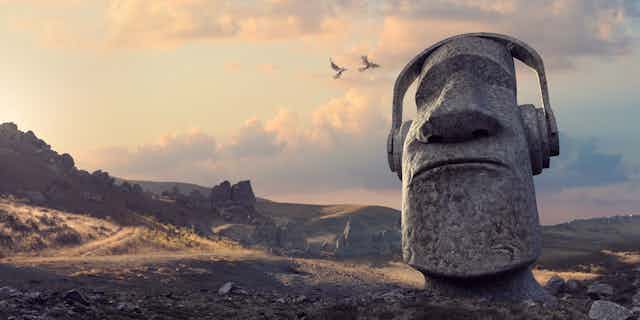 A stone statue of a head wearing headphones as if listening to music.