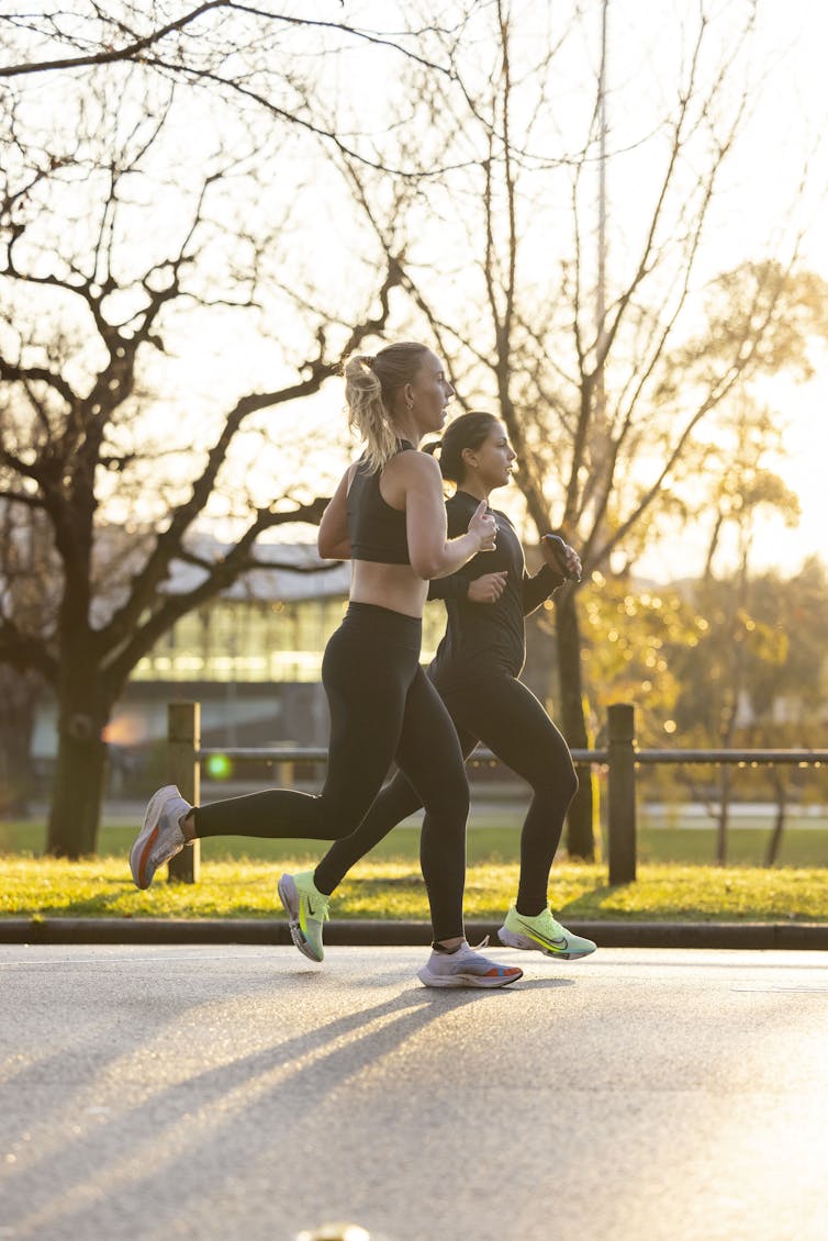 Two women on a training run through a park