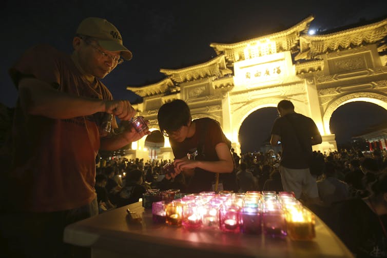 Protesters light candles at a night-time vigil.