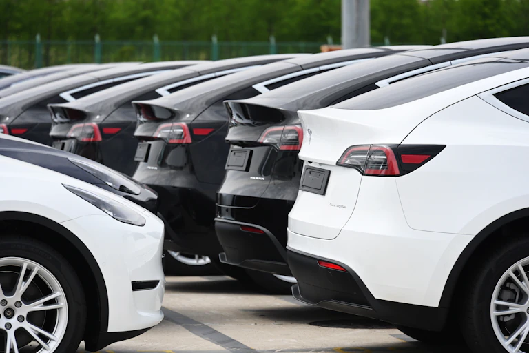 Several new Tesla cars parked in alot