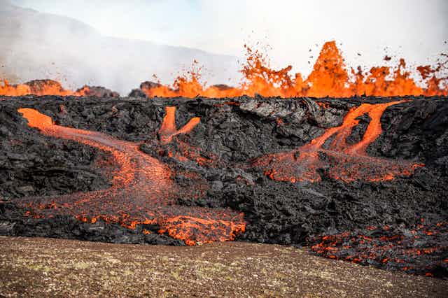 Magma flows out of an active rupture in the blackened earth