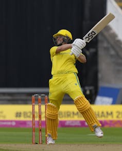 A young First Nations person named Ashleigh Gardner bats during the women's cricket at the 2022 Commonwealth Games.