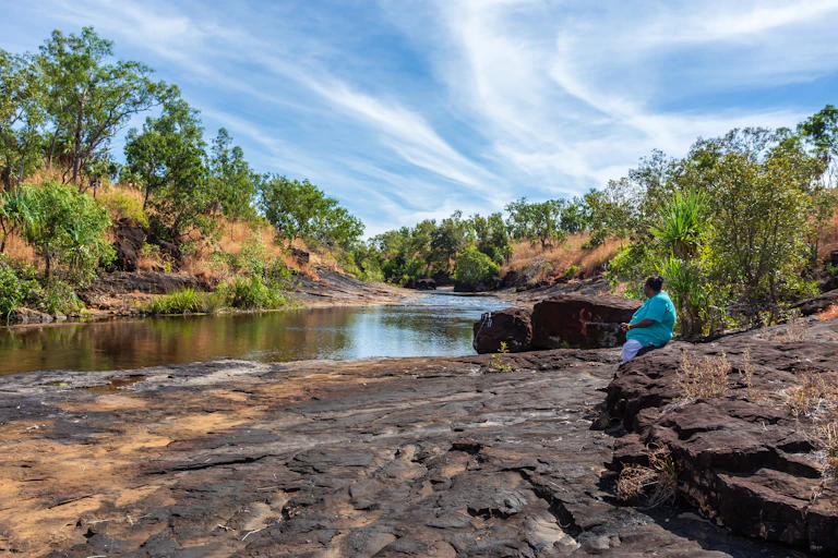 woman sits in remote landscape