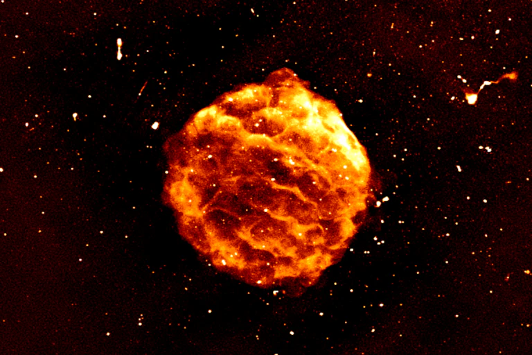 A bubbling red ball hangs in a dark background surrounded by points of light