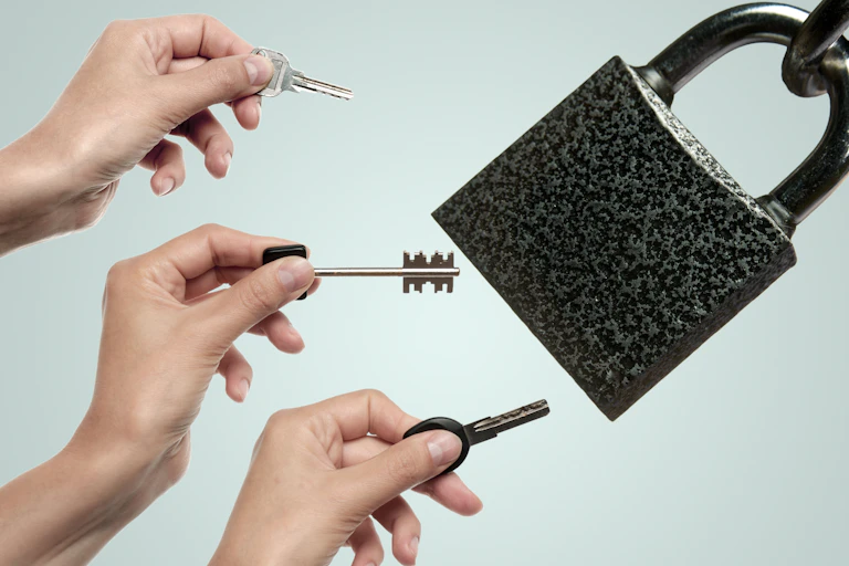 Three hands with different keys and a large padlock