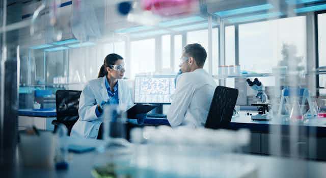 Dos investigadores conversando en un laboratorio.