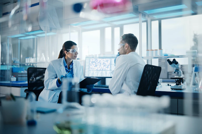 Dos investigadores conversando en un laboratorio.