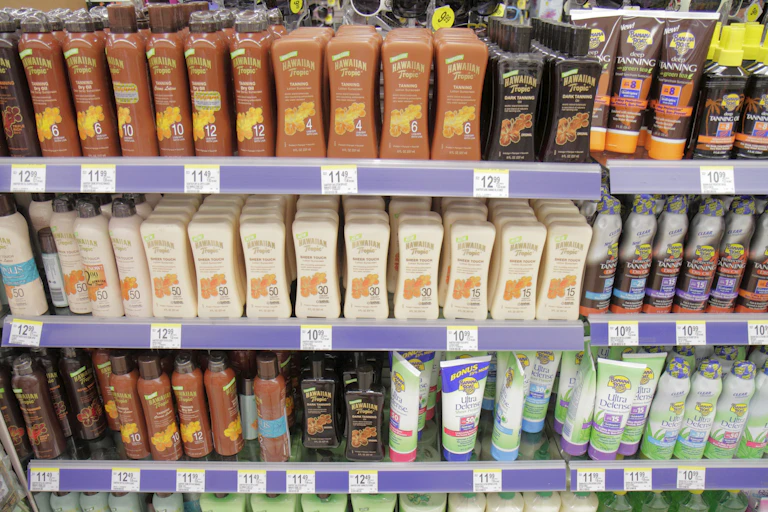 Four shelves in a ddrugstore crammed with bottles and cans of sunscreen