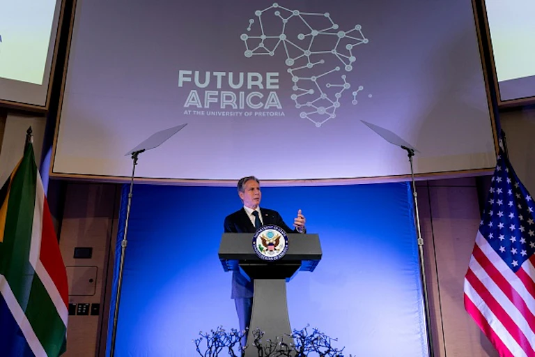 Man on grey suit speaking over a lectern.