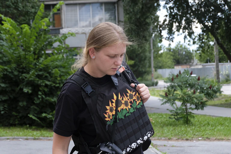 Jeune femme dans une rue en gilet pare-balles.
