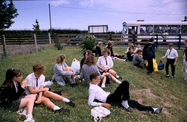 Schoolchildren sat on grass