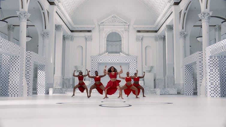 A group of dancers in a white setting