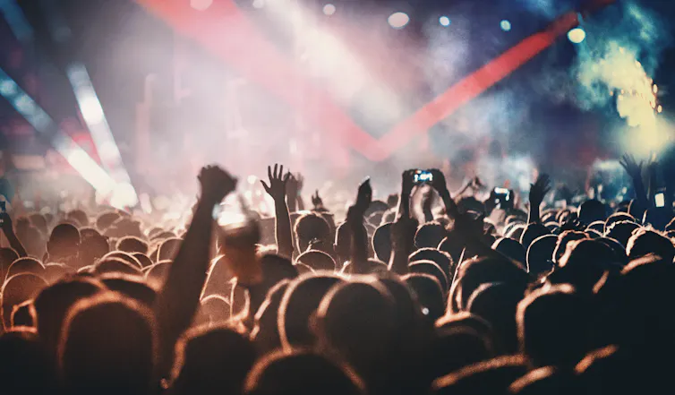 People enjoying a rock concert with a light show