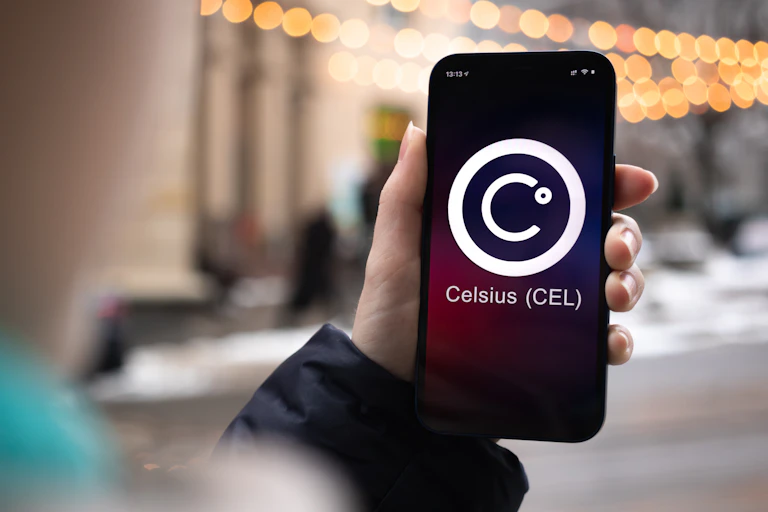 A hand holding a cellphone with the crypto platform Celsius logo on the screen