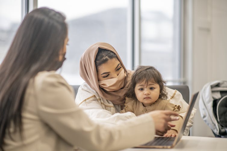 Migrant mother and a child with another woman.