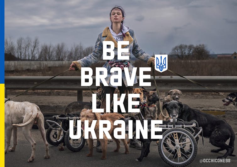 A white woman is shown holding the leashes of several dogs, with the words 'Be brave like Ukraine' in big text over her