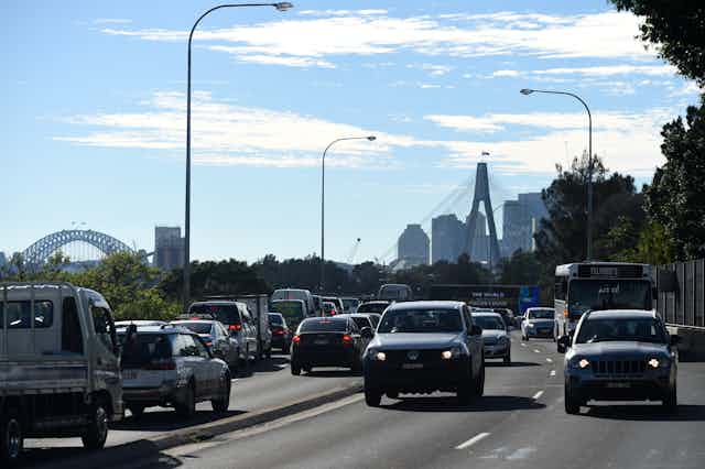 four lanes of traffic with city skyline in background