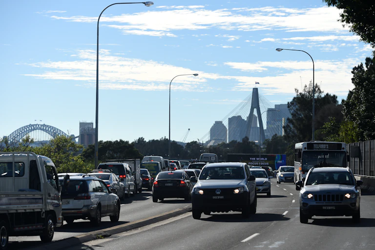 four lanes of traffic with city skyline in background