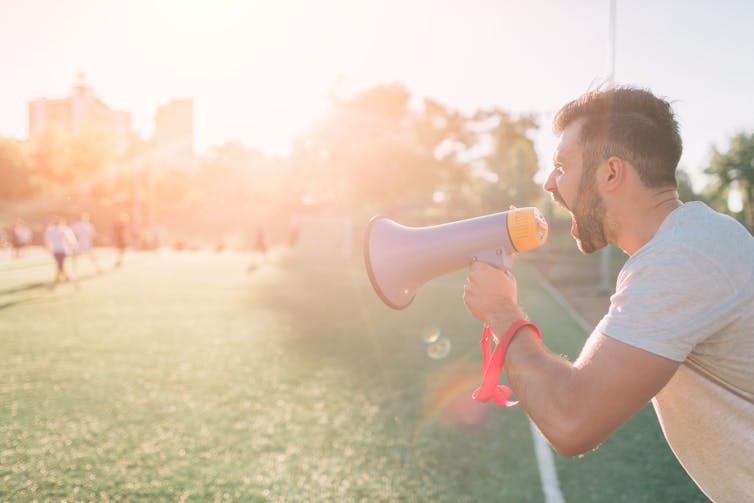 Coach yelling at his players through a megaphone