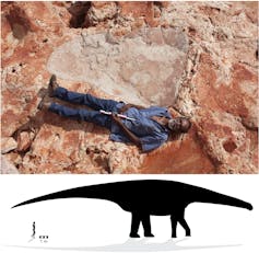 A man in dark jeans and a blue shirt lying next to a patch of red rock that is as long as he is