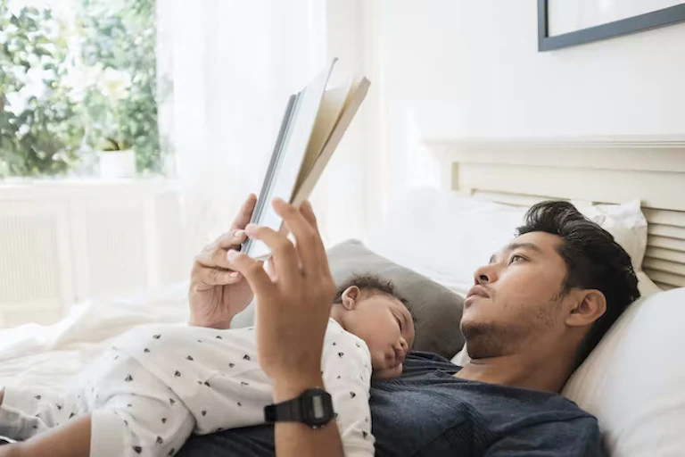bayi tengkurap tidur telentang membaca dada seorang pria