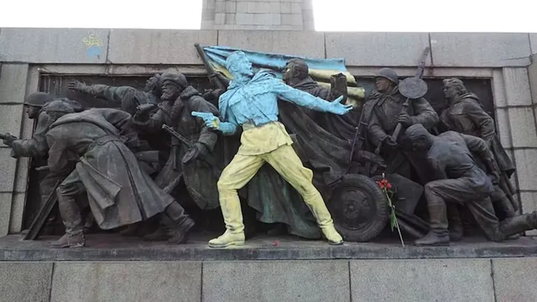 Memorial with freize of soldiers, one painted yellow and blue.