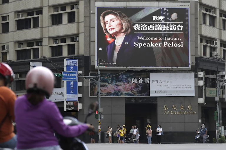 Un panneau d'affichage situé dans une rue passante affiche le visage de Nancy Pelosi et lui souhaite la bienvenue à Taïwan.