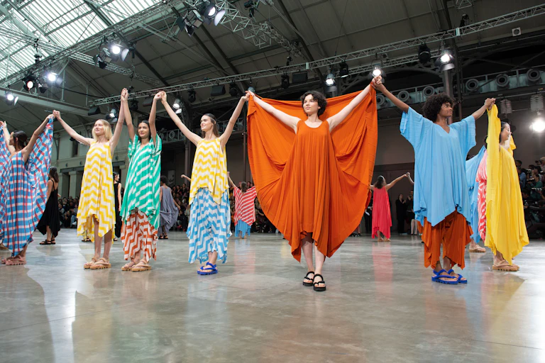 Models showing off dresses at fashion show.