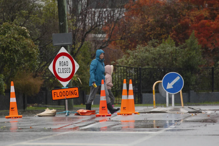 People crossing a road during a flood