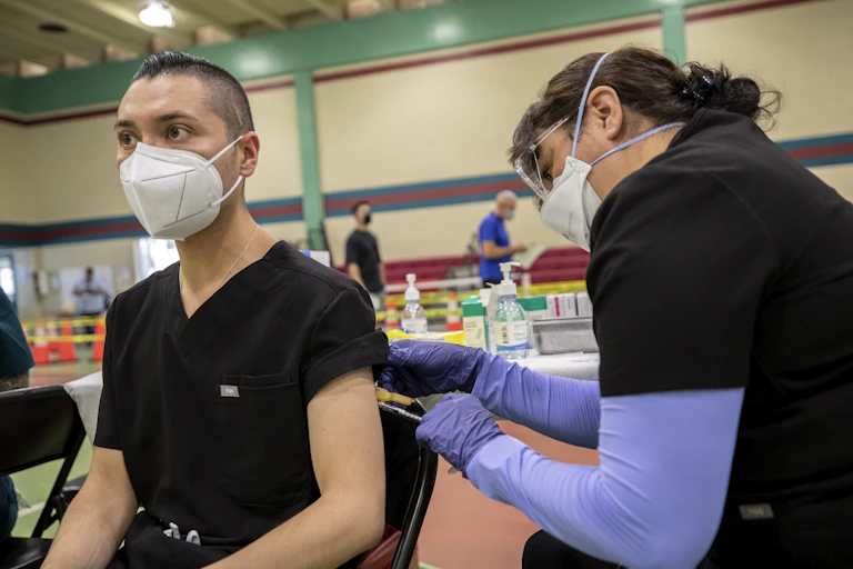 Man in a mask gets vaccinated against monkeypox