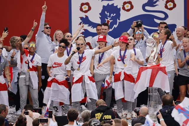Group of people with England flags in front of crowd