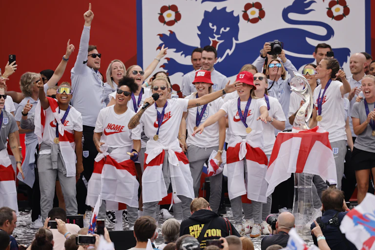 Group of people with England flags in front of crowd