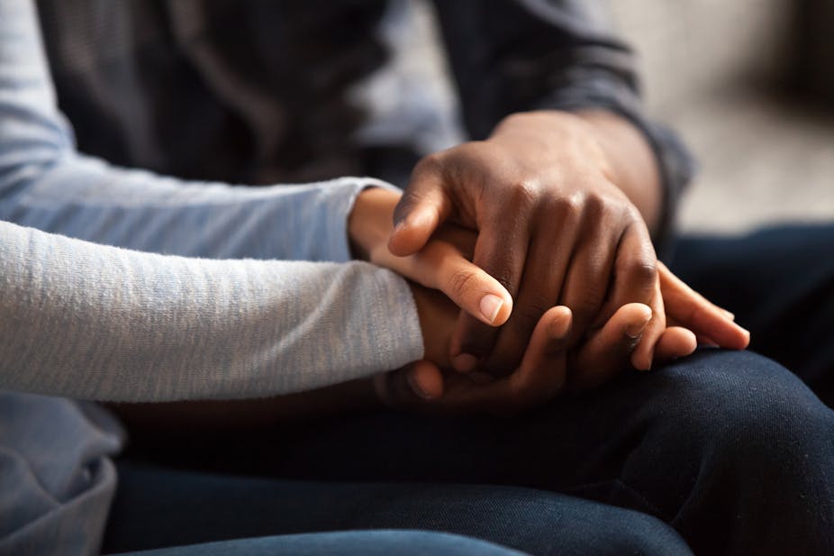 Close up of black couple holding hands 