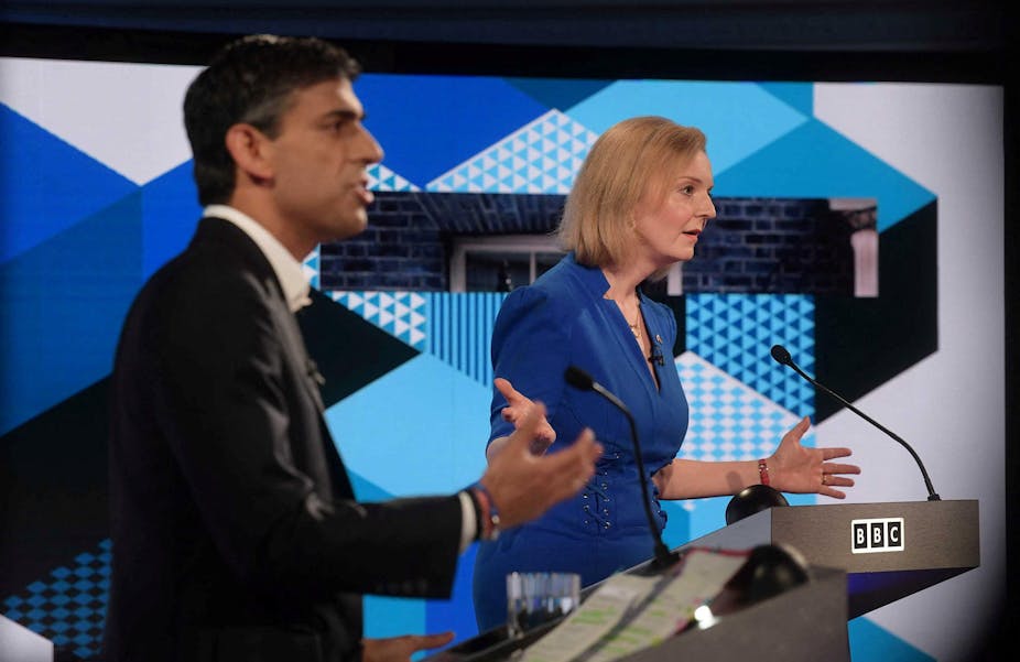 Side view of Rishi Sunak and Liz Truss speaking at podiums during a televised debate.