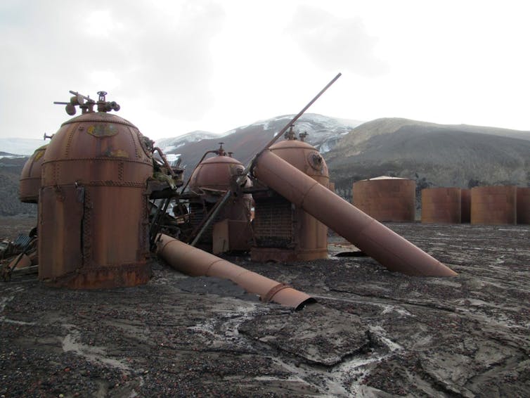 Large metal vessels on a stony beach