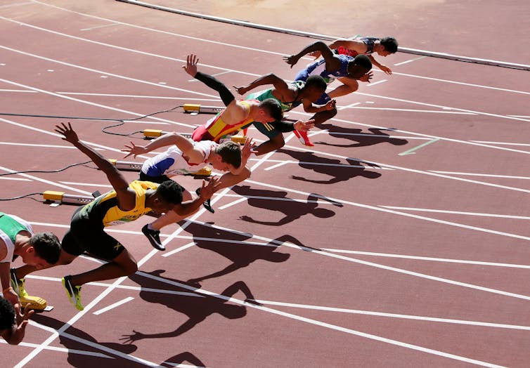 A group of sprinters on the starting line of a race.