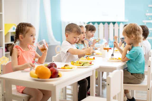 Niños comiendo sano en un comedor escolar.