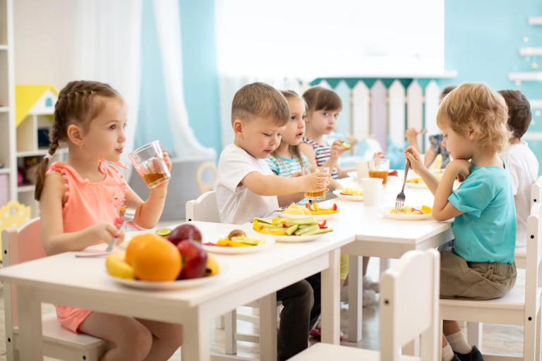 Niños comiendo sano en un comedor escolar.