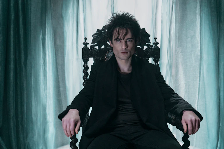 Man sits in a chair in dark room.