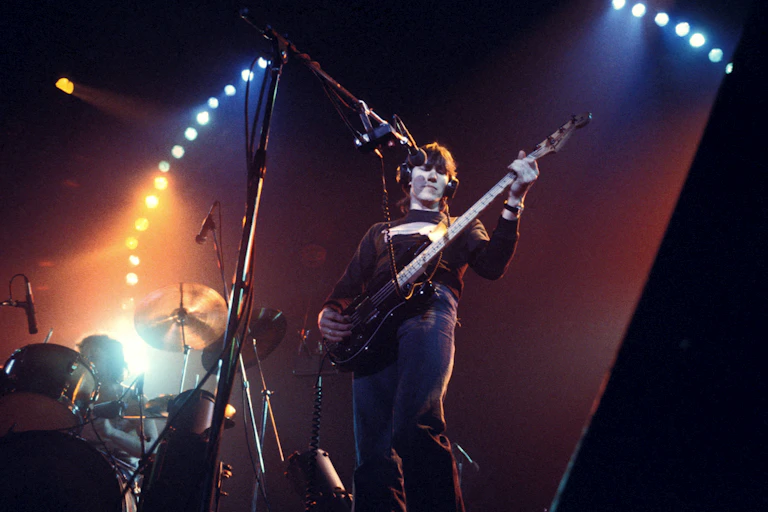 Man plays bass guitar on stage.