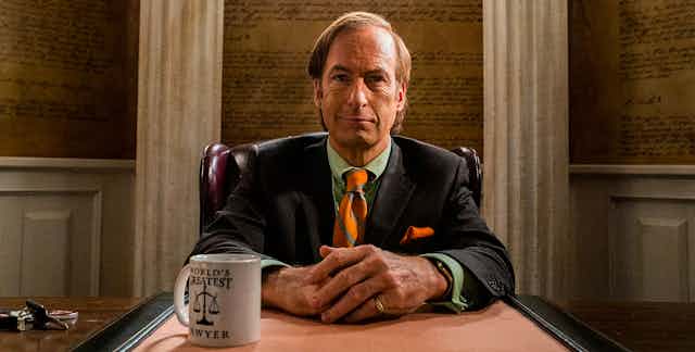 Actor Bob Odenkirk as the character Saul Goodman sits at his desk.