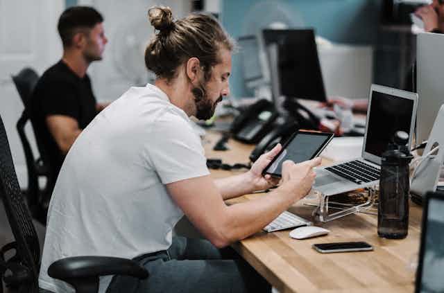 Man at desk using tablet